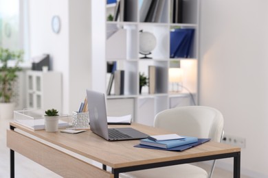 Photo of Doctor's workplace with modern laptop on desk in office
