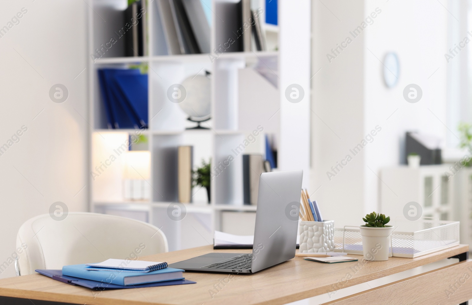 Photo of Doctor's workplace with modern laptop on desk in office