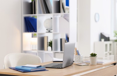Photo of Doctor's workplace with modern laptop on desk in office