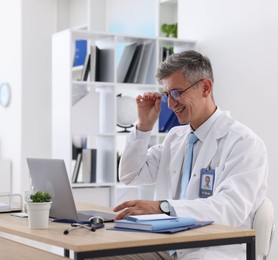 Photo of Telemedicine. Doctor having video call with patient via laptop indoors