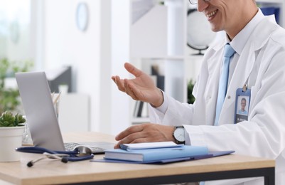 Photo of Telemedicine. Doctor having video call with patient via laptop indoors, closeup