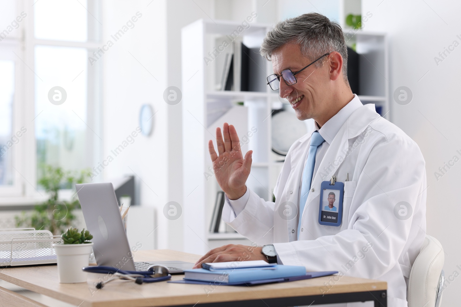 Photo of Telemedicine. Doctor having video call with patient via laptop indoors