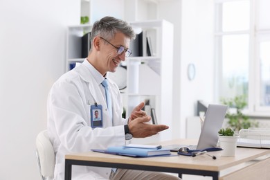 Photo of Telemedicine. Doctor having video call with patient via laptop indoors