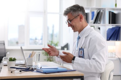 Photo of Telemedicine. Doctor having video call with patient via laptop indoors