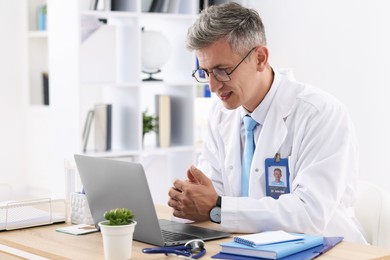 Photo of Telemedicine. Doctor having video call with patient via laptop indoors