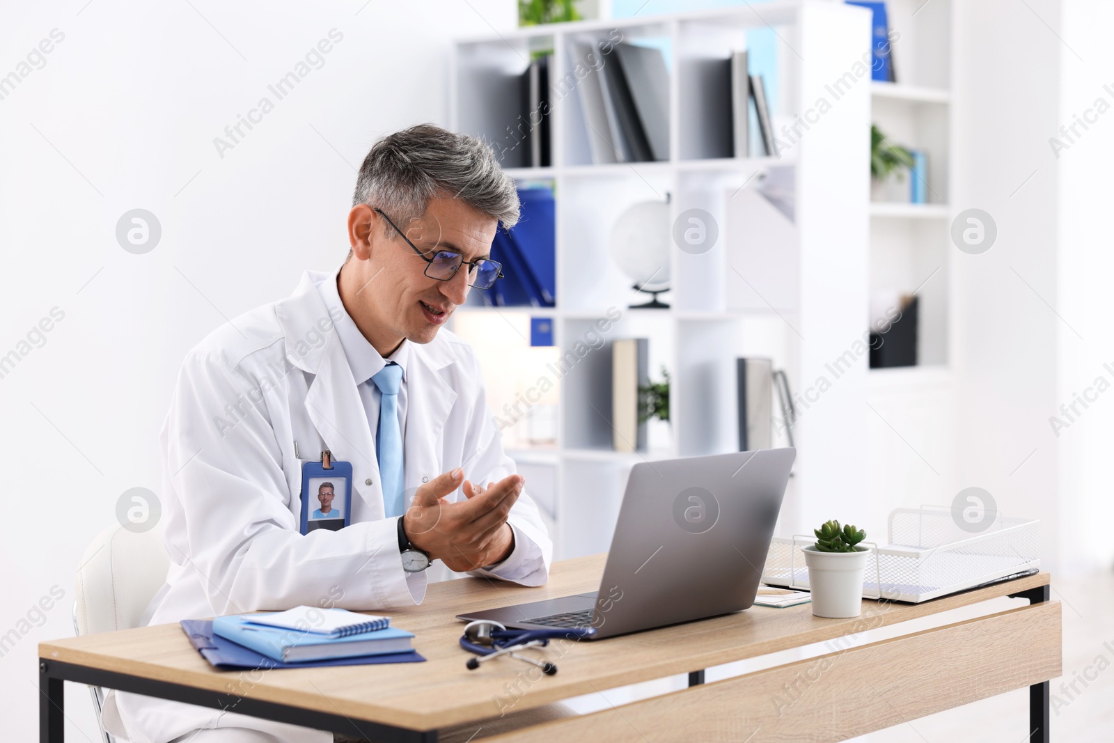 Photo of Telemedicine. Doctor having video call with patient via laptop indoors