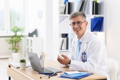 Photo of Telemedicine. Doctor having video call with patient via laptop indoors