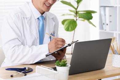 Photo of Telemedicine. Doctor having video call with patient via laptop indoors, closeup