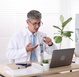 Photo of Telemedicine. Doctor having video call with patient via laptop indoors