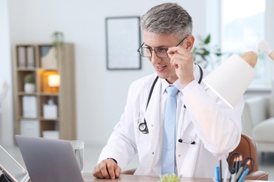 Photo of Telemedicine. Doctor having video call with patient via laptop indoors