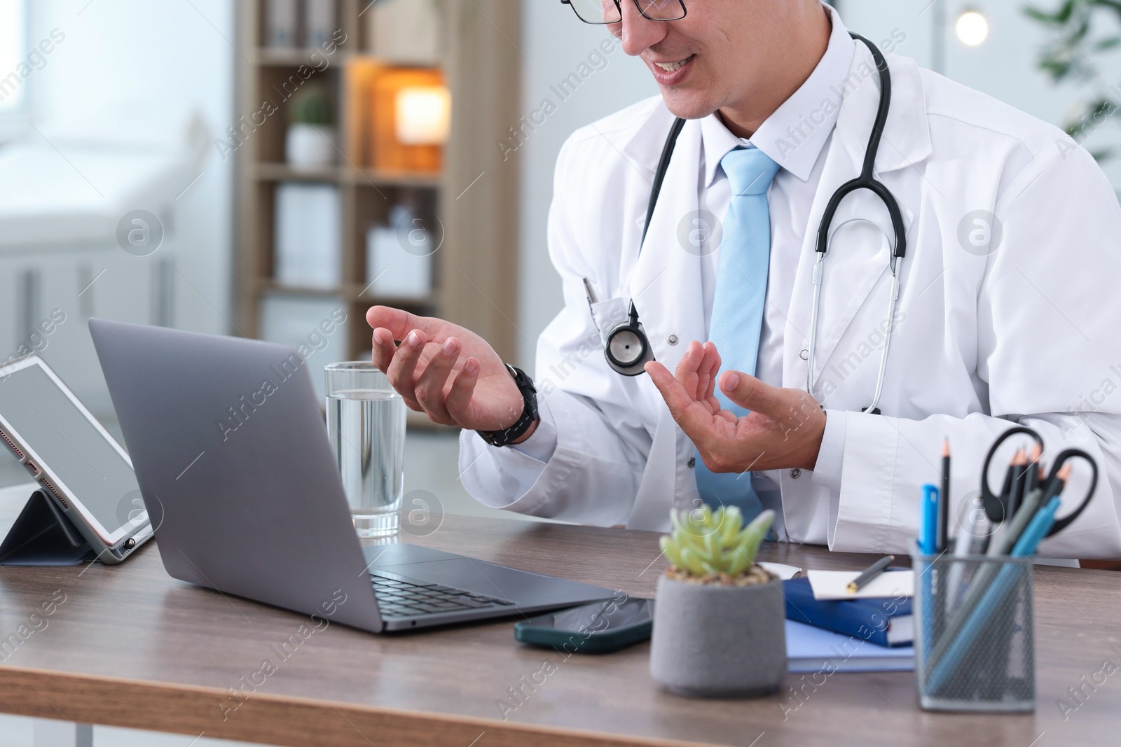 Photo of Telemedicine. Doctor having video call with patient via laptop indoors, closeup