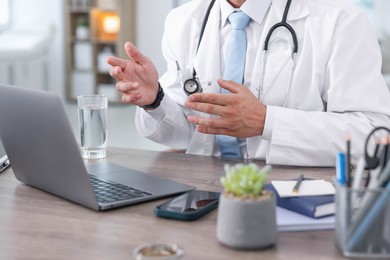 Photo of Telemedicine. Doctor having video call with patient via laptop indoors, closeup