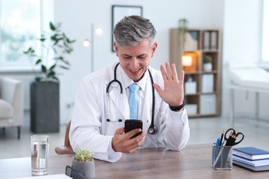 Photo of Telemedicine. Doctor having video call with patient via smartphone indoors
