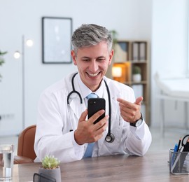 Photo of Telemedicine. Doctor having video call with patient via smartphone indoors