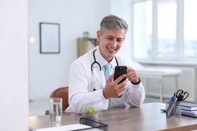 Photo of Telemedicine. Doctor having video call with patient via smartphone indoors