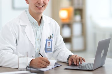 Photo of Telemedicine. Doctor having video call with patient via laptop indoors, closeup