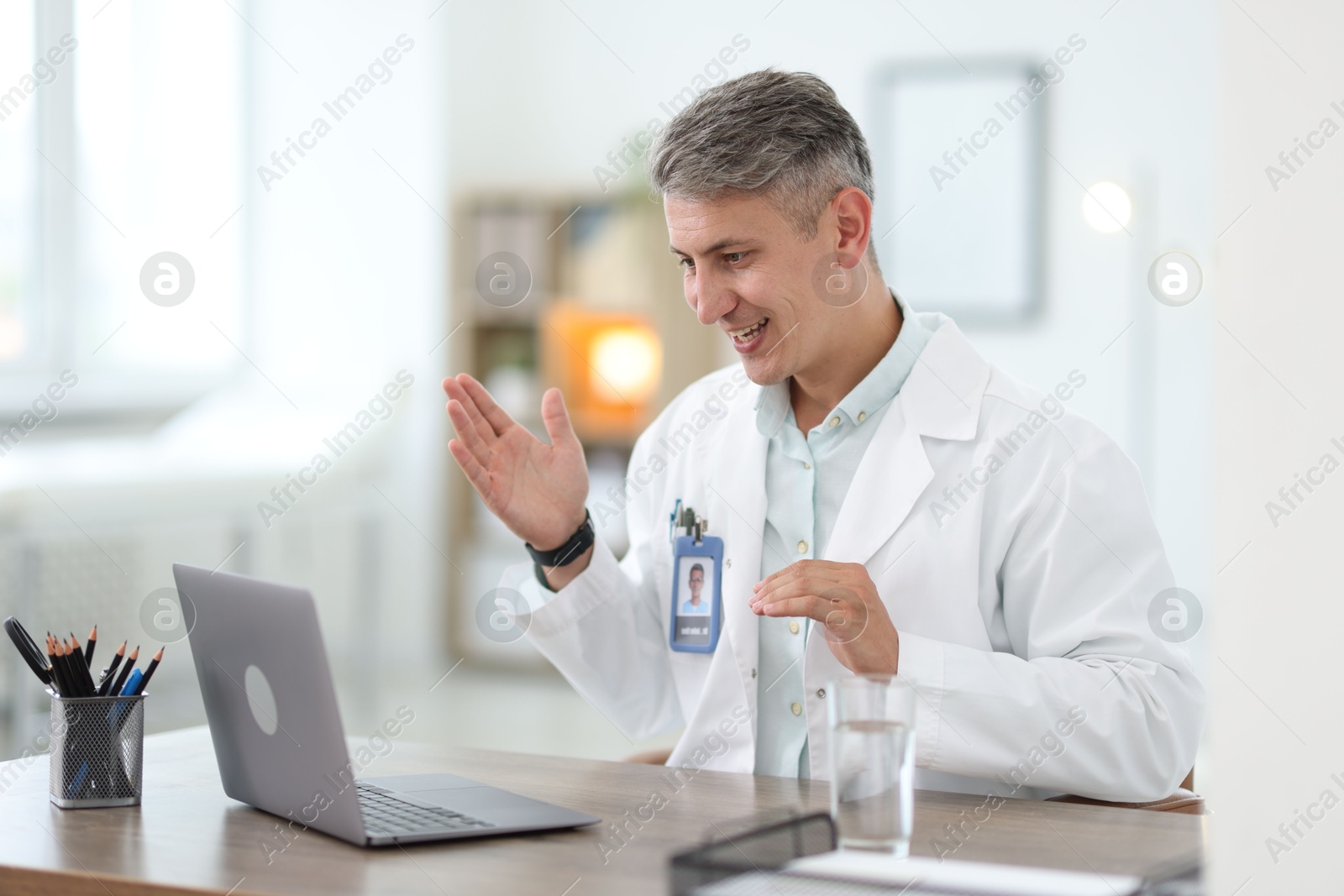 Photo of Telemedicine. Doctor having video call with patient via laptop indoors