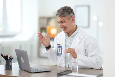 Photo of Telemedicine. Doctor having video call with patient via laptop indoors
