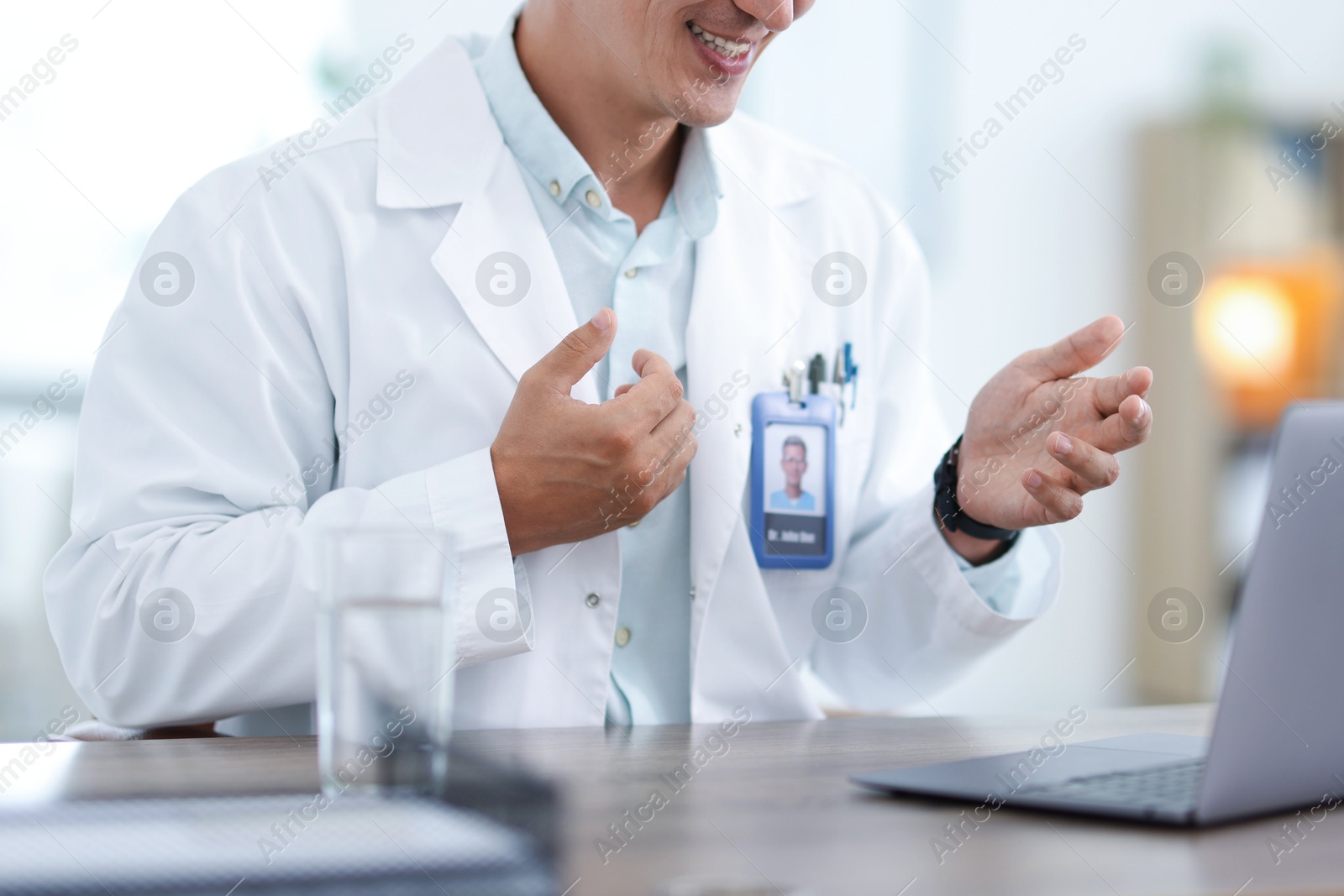 Photo of Telemedicine. Doctor having video call with patient via laptop indoors, closeup