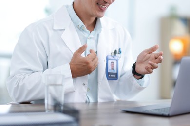 Photo of Telemedicine. Doctor having video call with patient via laptop indoors, closeup