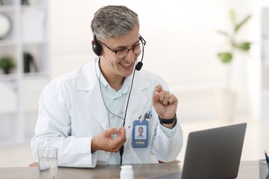 Photo of Telemedicine. Doctor recommending pills to patient during video call via laptop indoors