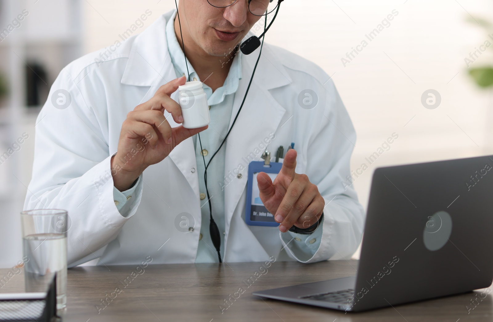 Photo of Telemedicine. Doctor recommending pills to patient during video call via laptop indoors, closeup