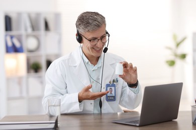 Photo of Telemedicine. Doctor recommending pills to patient during video call via laptop indoors