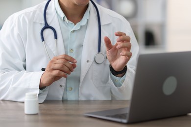 Photo of Telemedicine. Doctor having video call with patient via laptop indoors, closeup