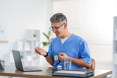 Photo of Telemedicine. Doctor having video call with patient via laptop indoors
