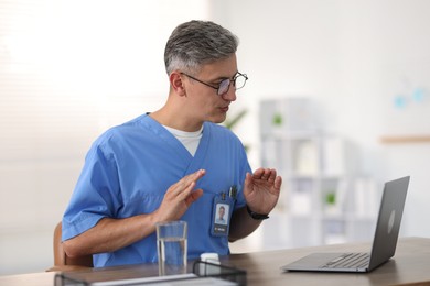 Photo of Telemedicine. Doctor having video call with patient via laptop indoors