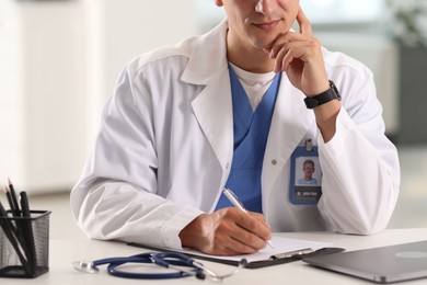 Photo of Doctor making notes during consultation with patient indoors, closeup