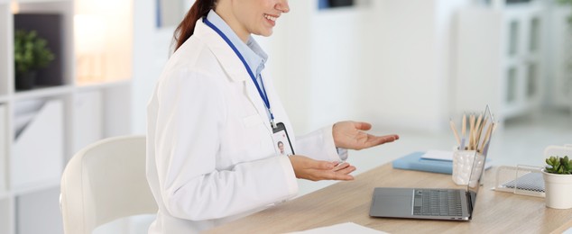 Photo of Telemedicine. Doctor having video call with patient via laptop indoors, closeup