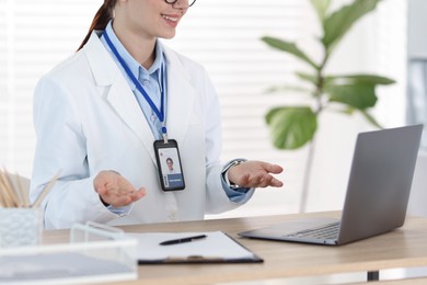 Photo of Telemedicine. Doctor having video call with patient via laptop indoors, closeup