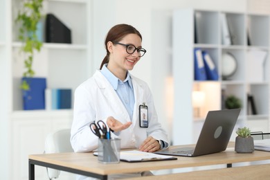 Photo of Telemedicine. Doctor having video call with patient via laptop indoors