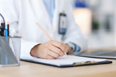 Photo of Telemedicine. Doctor making notes while having consultation with patient indoors, closeup