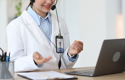 Photo of Telemedicine. Doctor having video call with patient via laptop indoors, closeup