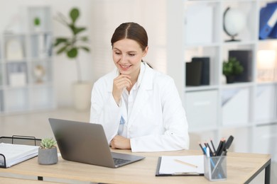 Photo of Telemedicine. Doctor having video call with patient via laptop indoors