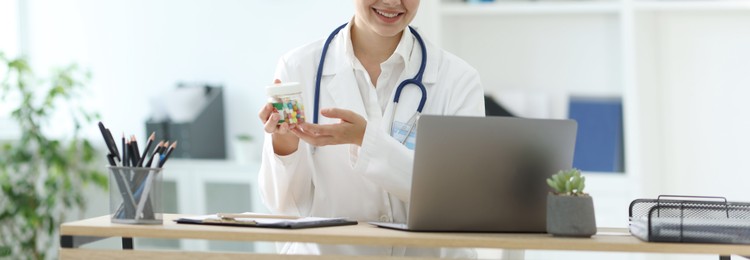 Photo of Telemedicine. Doctor recommending pills to patient during video call via laptop indoors, closeup