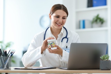 Photo of Telemedicine. Doctor recommending pills to patient during video call via laptop indoors