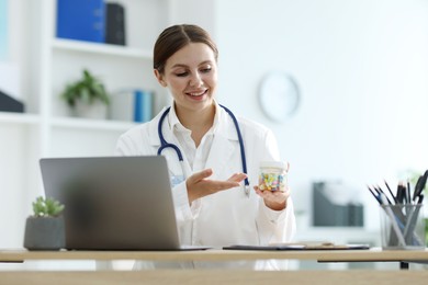 Photo of Telemedicine. Doctor recommending pills to patient during video call via laptop indoors