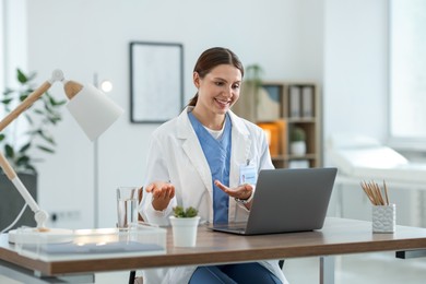 Photo of Telemedicine. Doctor having video call with patient via laptop indoors