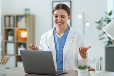 Photo of Telemedicine. Doctor having video call with patient via laptop indoors