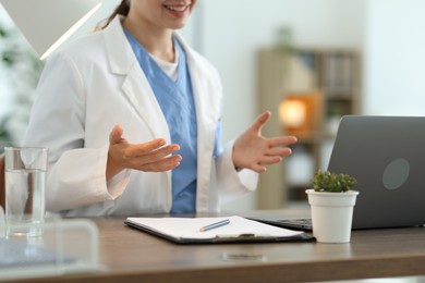 Photo of Telemedicine. Doctor having video call with patient via laptop indoors, closeup