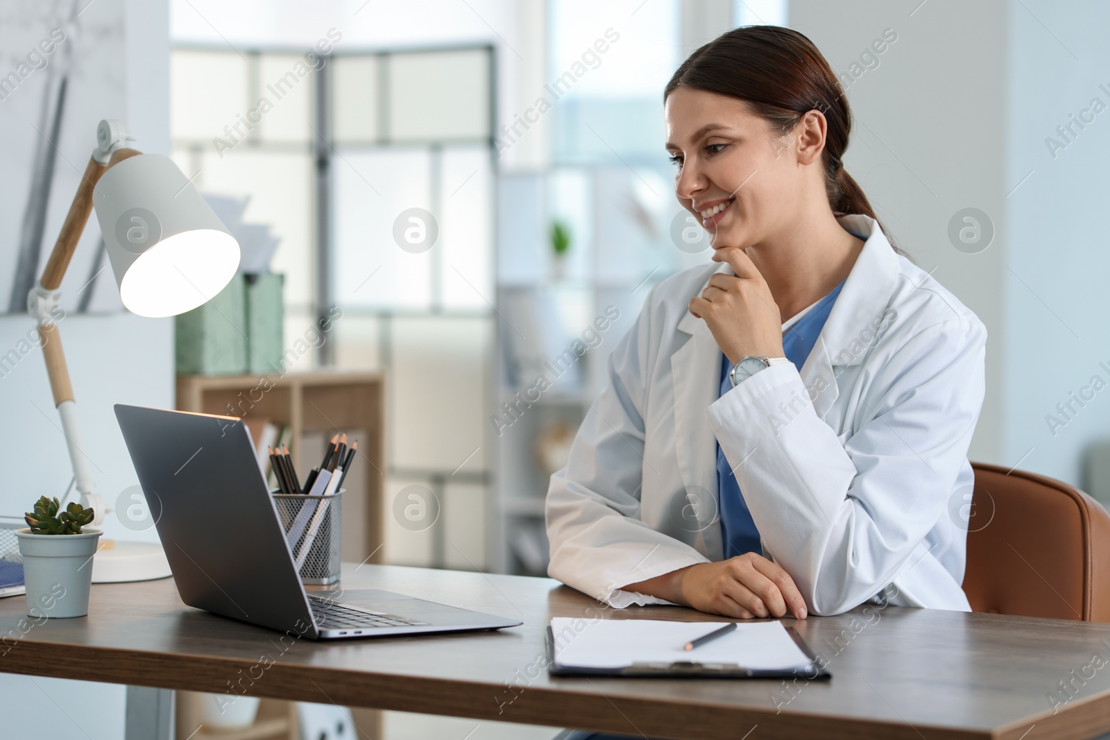 Photo of Telemedicine. Doctor having video call with patient via laptop indoors