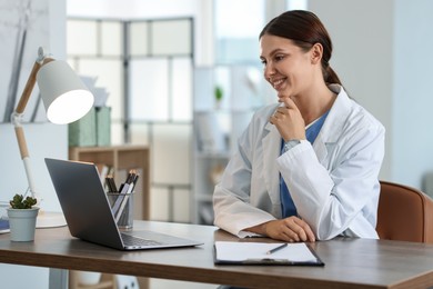Photo of Telemedicine. Doctor having video call with patient via laptop indoors