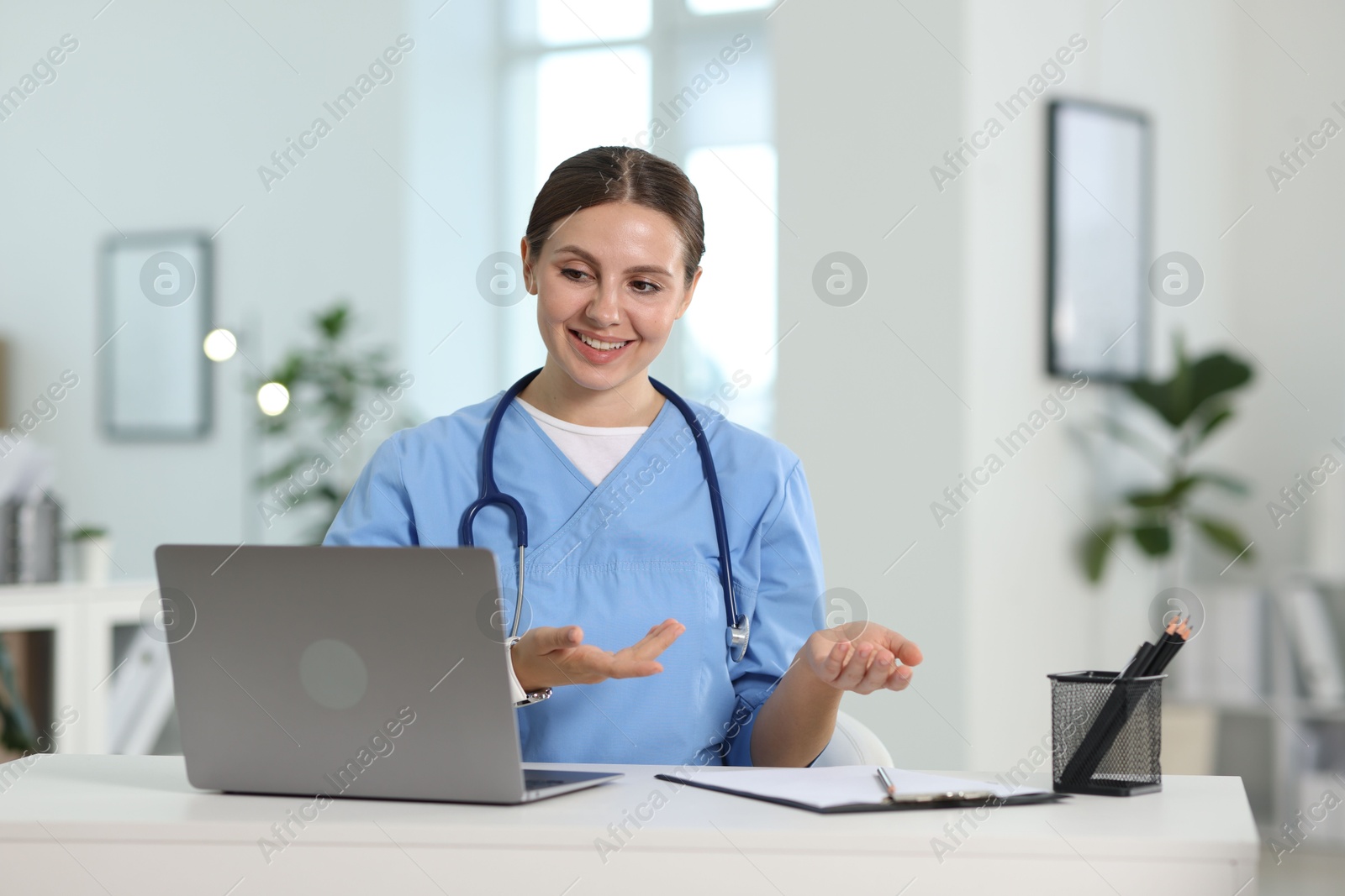 Photo of Telemedicine. Doctor having video call with patient via laptop indoors