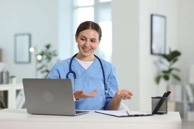 Photo of Telemedicine. Doctor having video call with patient via laptop indoors