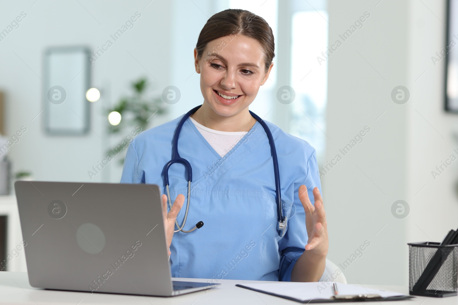 Photo of Telemedicine. Doctor having video call with patient via laptop indoors