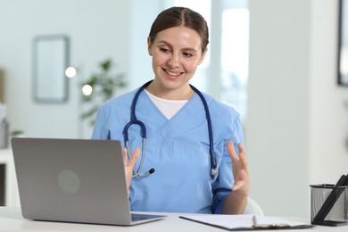 Photo of Telemedicine. Doctor having video call with patient via laptop indoors