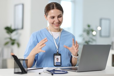 Photo of Telemedicine. Doctor having video call with patient via laptop indoors